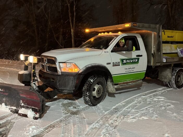 Alt Text: Lily Silvis plowing a commercial property in Greensburg Pa using a Silvis Group Truck with a SnowEx® Plow Head with a SnowEx® Tailgate Spreader