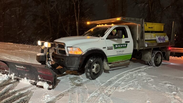 Alt Text: Lily Silvis plowing a commercial property in Greensburg Pa using a Silvis Group Truck with a SnowEx® Plow Head with a SnowEx® Tailgate Spreader