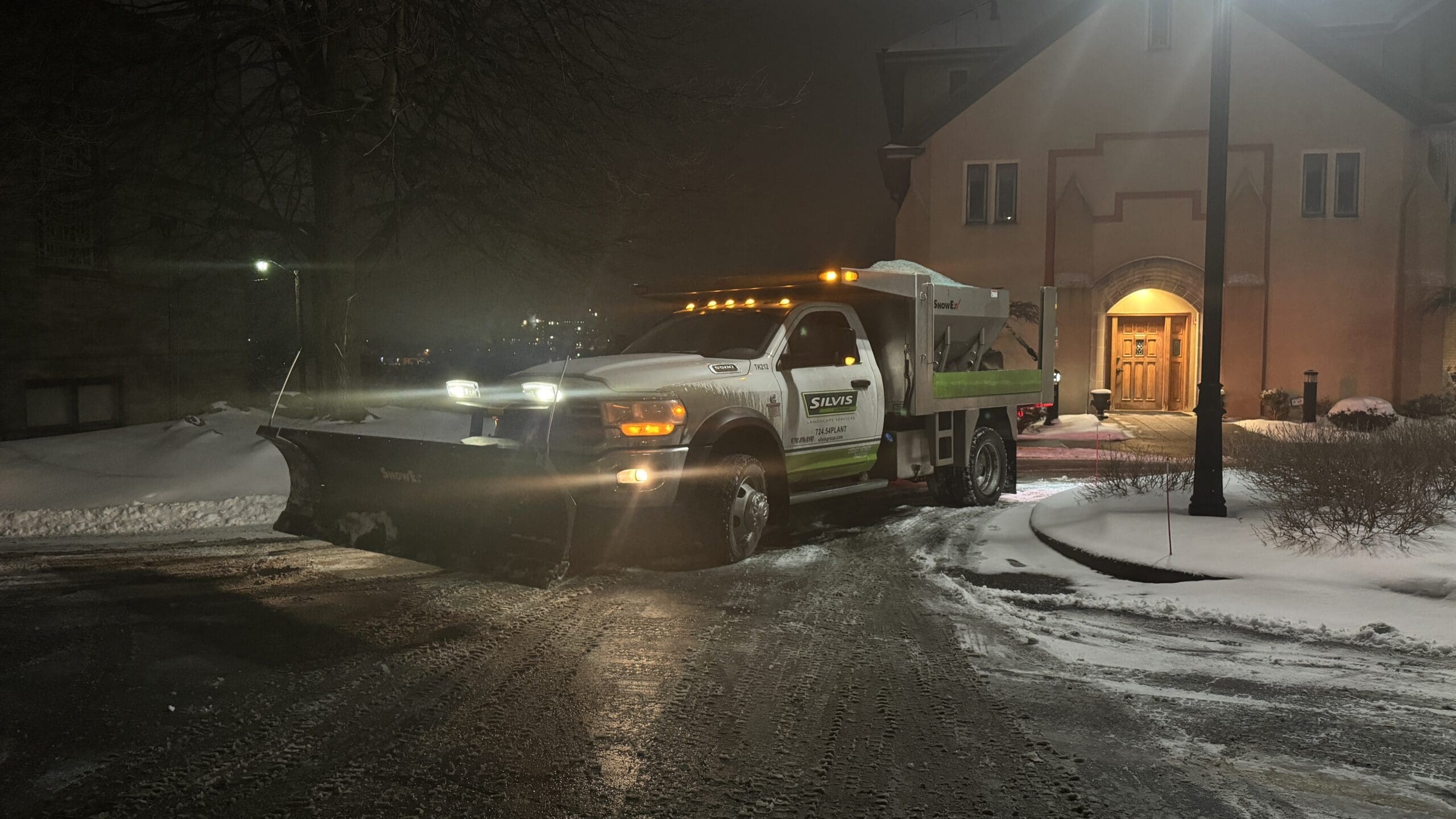 Alt Text: Lily Silvis plowing a commercial property in Mount Pleasant Pa using a Silvis Group Truck with a SnowEx® Plow Head with a SnowEx HELIXX Stainless Steel Hopper Spreader